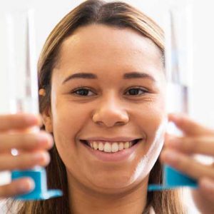 female student holding glass tube