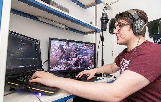 Former Games Development student Jordan Thorpe using a laptop computer.