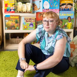 Lauren Chorley sat in front of a shelf of books